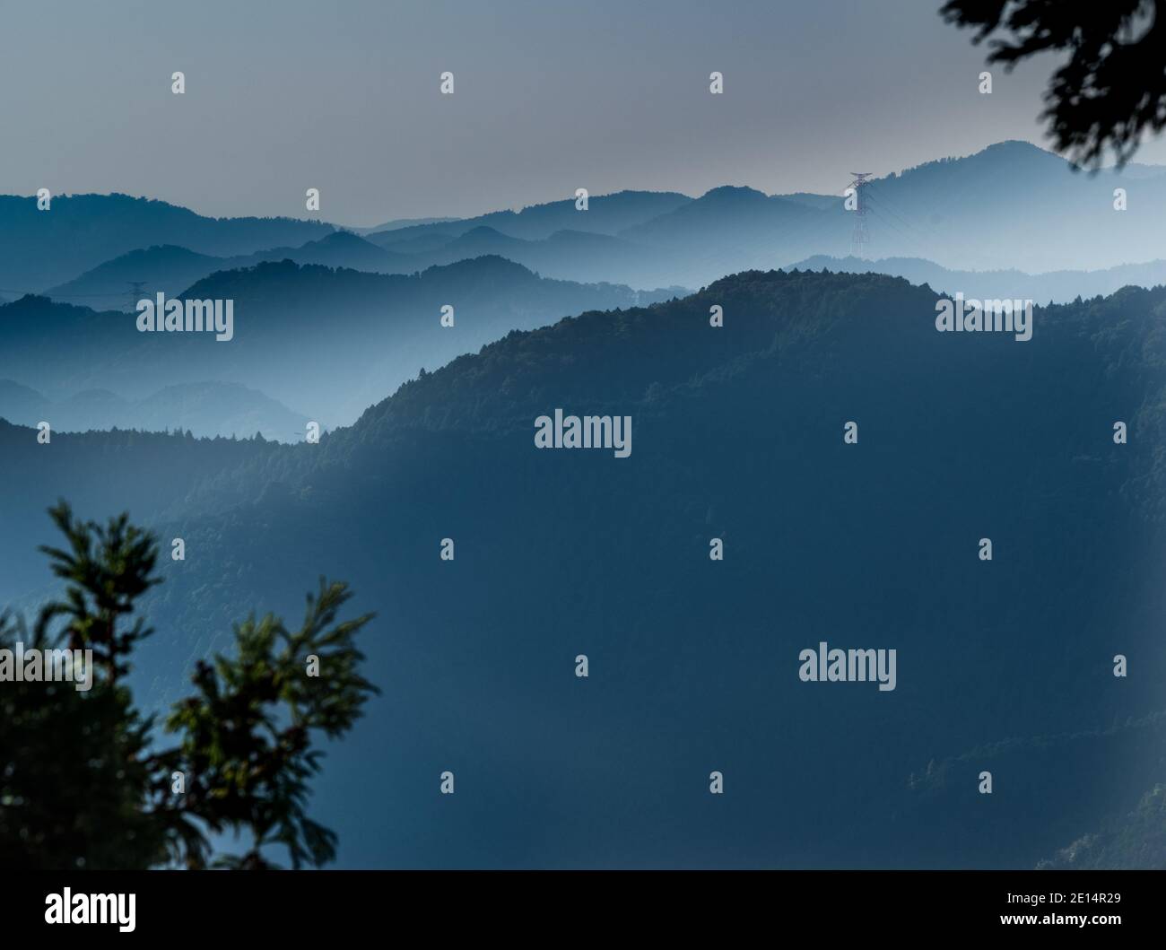 View of the mountain ridges bathed in morning mist after sunrise. Shot taken from peak of Mt. Mitake in the Chichibu-Tama-Kai National Park west of ce Stock Photo