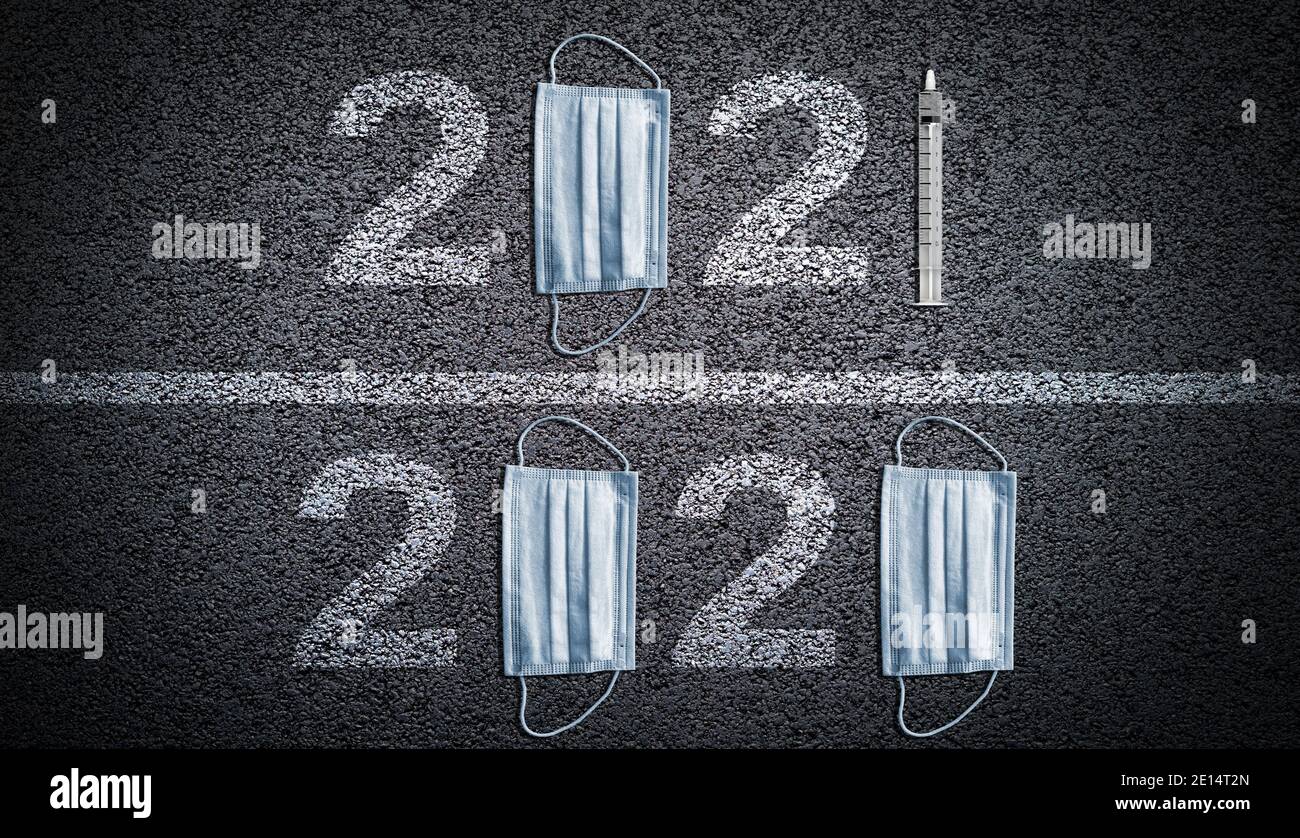 From year 2020 pandemic illustrated by pair of masks, to new year 2021 hope in COVID-19 vaccine illustrated by syringe needle on asphalt background. Stock Photo