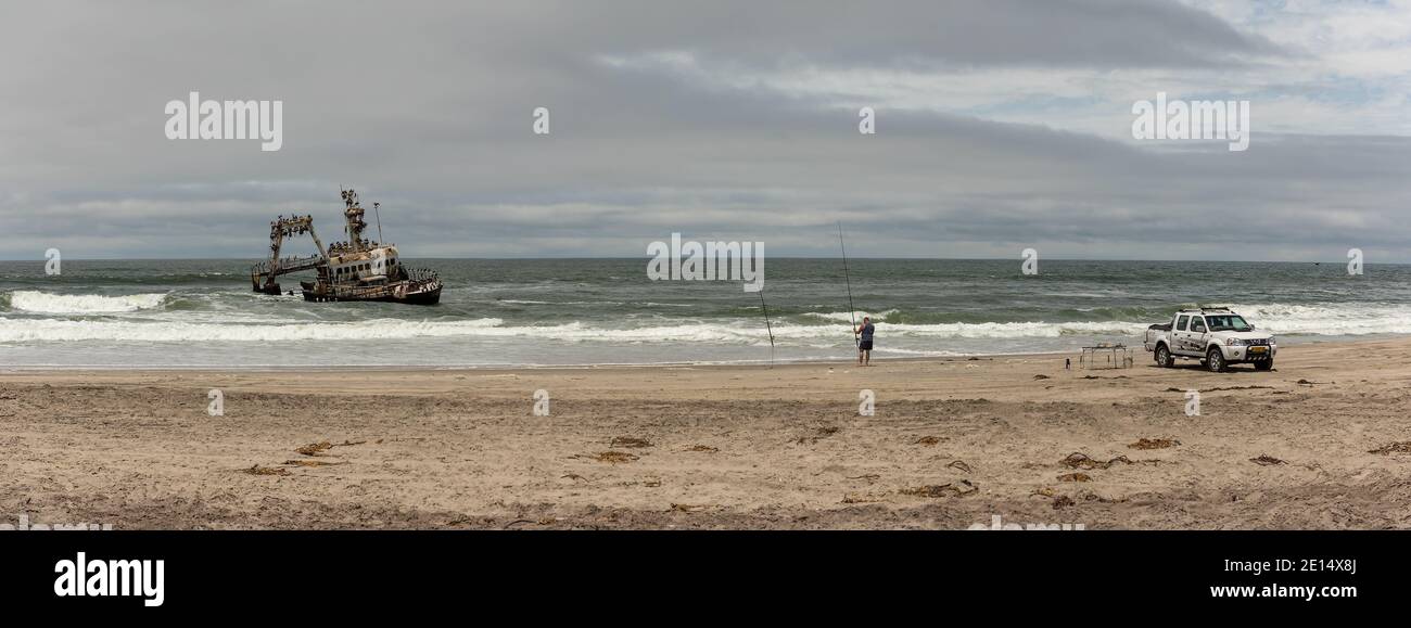 Surf fishing on the Skeleton Coast in front of the Zeila shipwreck, Namibia Stock Photo