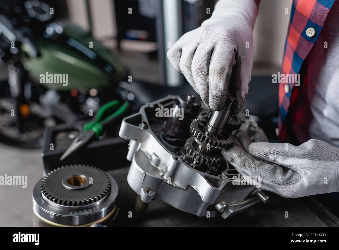 partial view of technician in gloves examining disassembled motorbike
