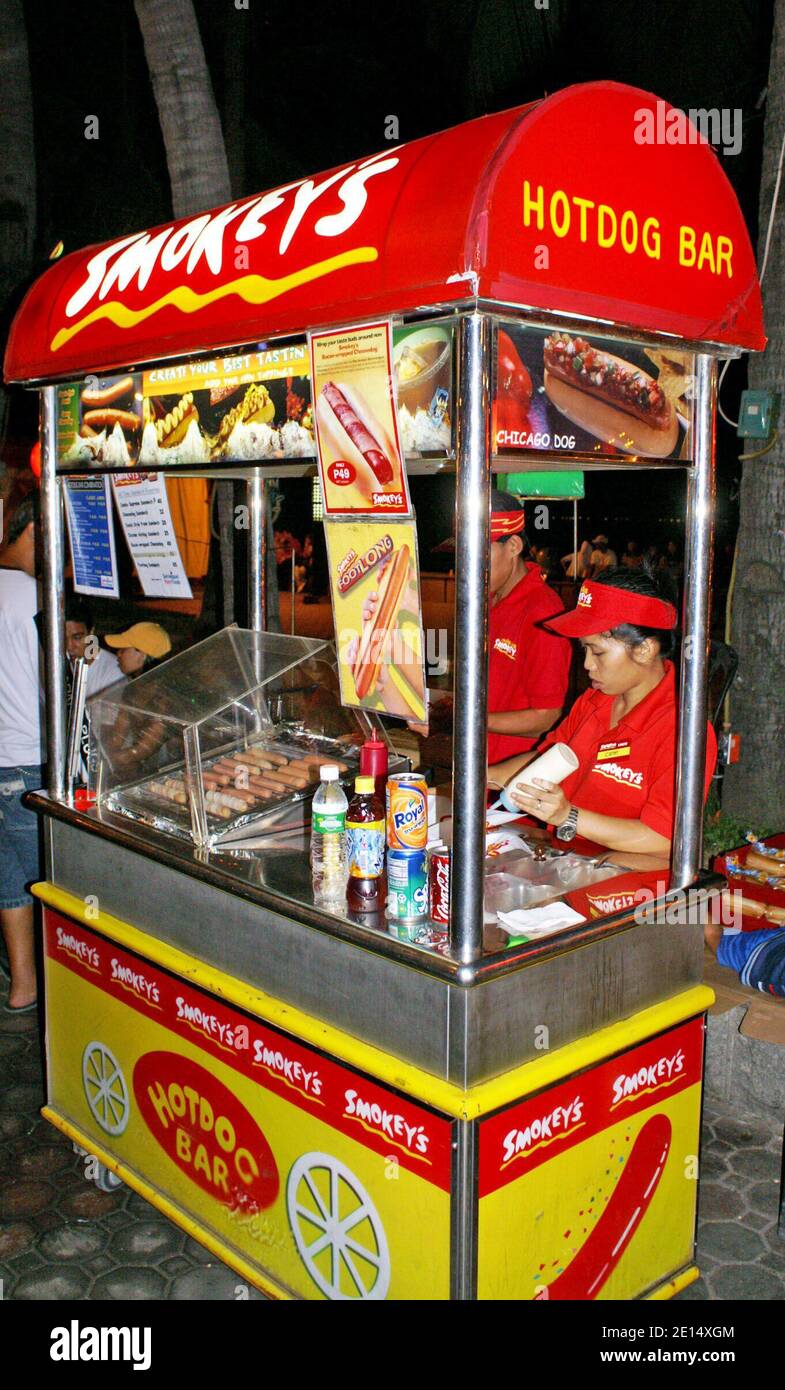 Smokey's Hot Dog bar along the promenade in Manila, Philippines, is an example of American influence on cuisine.  The mobile hot dog bar is an example of multicultural influences and the unique historic relationship with the United States. Stock Photo