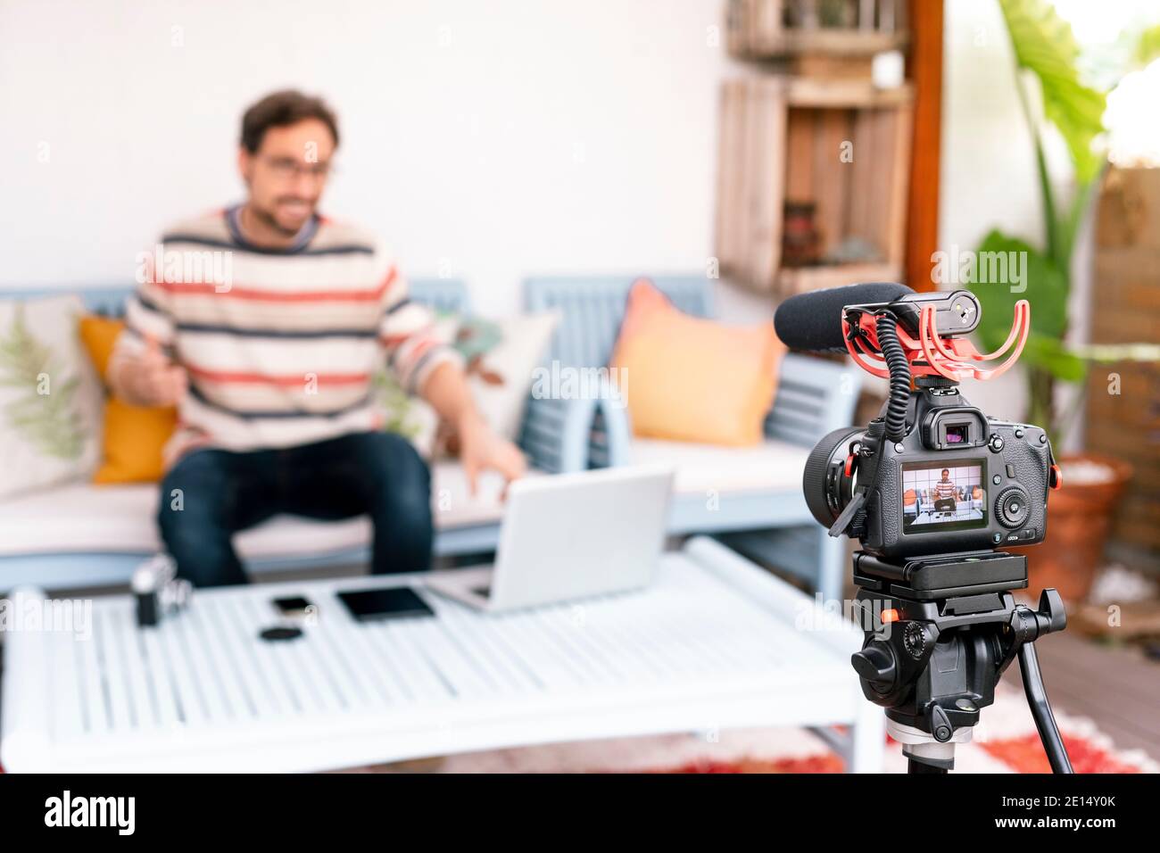 Camera screen showing a man pointing his computer screen. Focus on