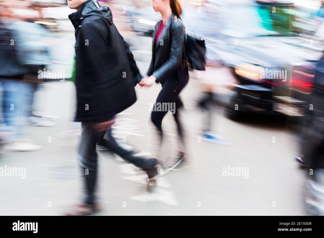 picture with camera made motion blur effect of a couple crossing a city ...