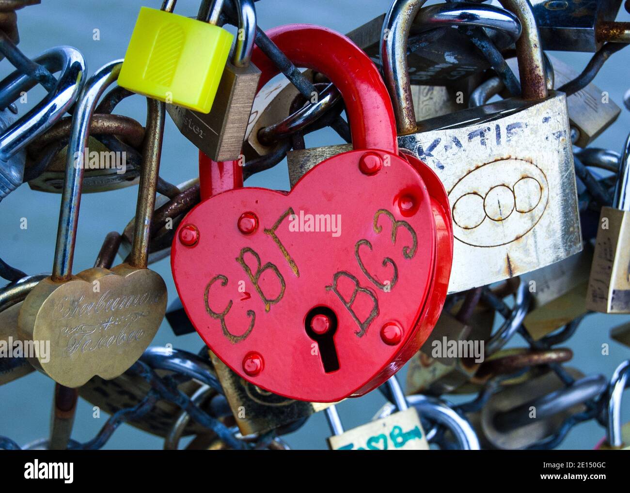 Red heart shape padlock among other love locks which are affixed to the
