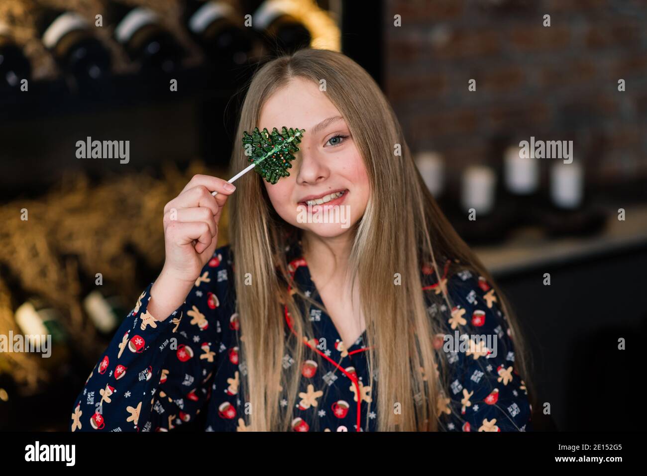 Amazed funny kid lick candy lollipop at home during winter holidays Stock Photo