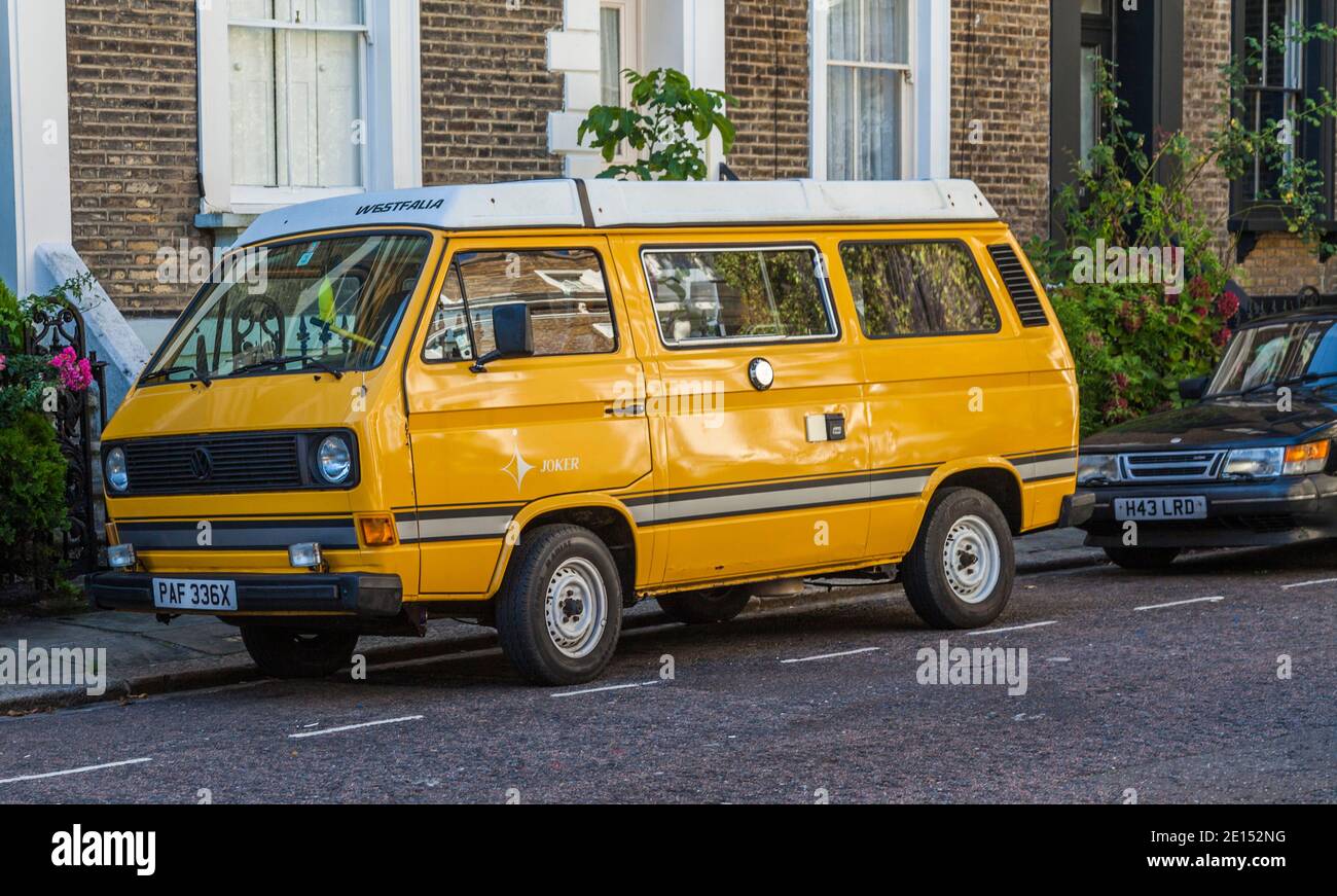 A yellow and white coloured VW camper van parked in a street in Hackney,London,England,UK Stock Photo