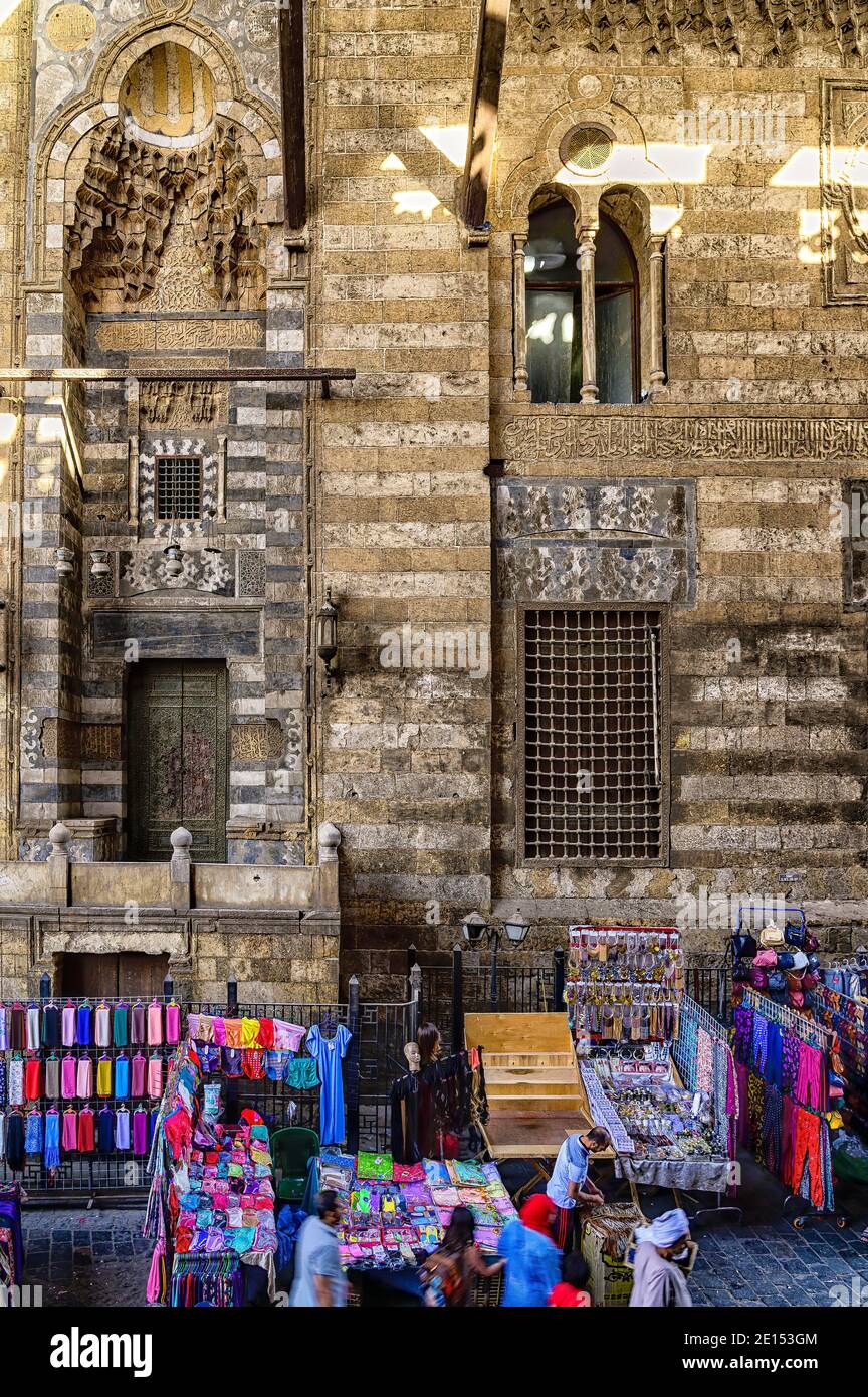 Market stalls in the square located between the two facades of the Funerary complex of Sultan al-Ghuri in Islamic Cairo Stock Photo