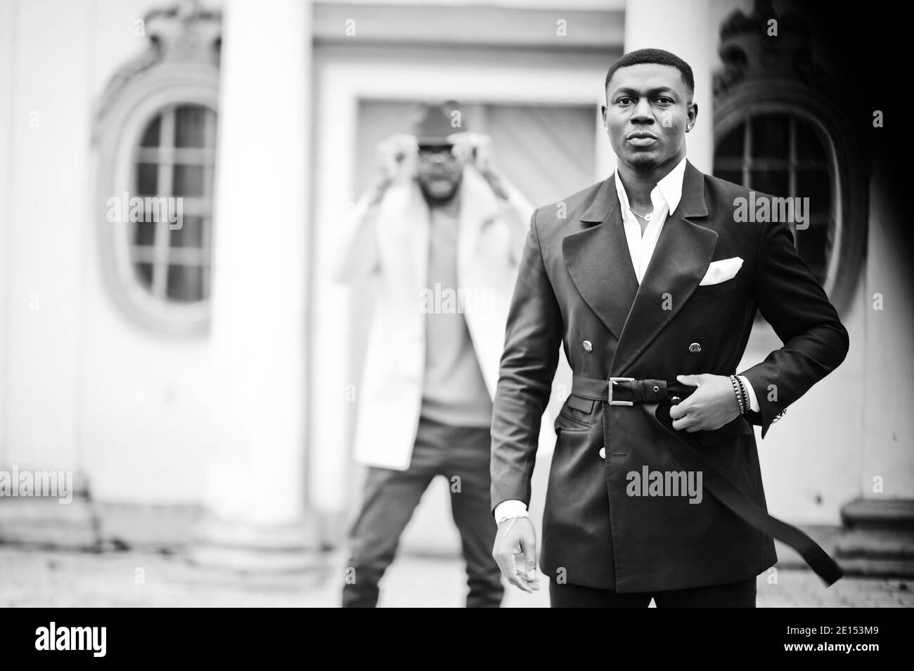 Two fashion black men. Fashionable portrait of african american male models. Wear suit, coat and hat. Stock Photo