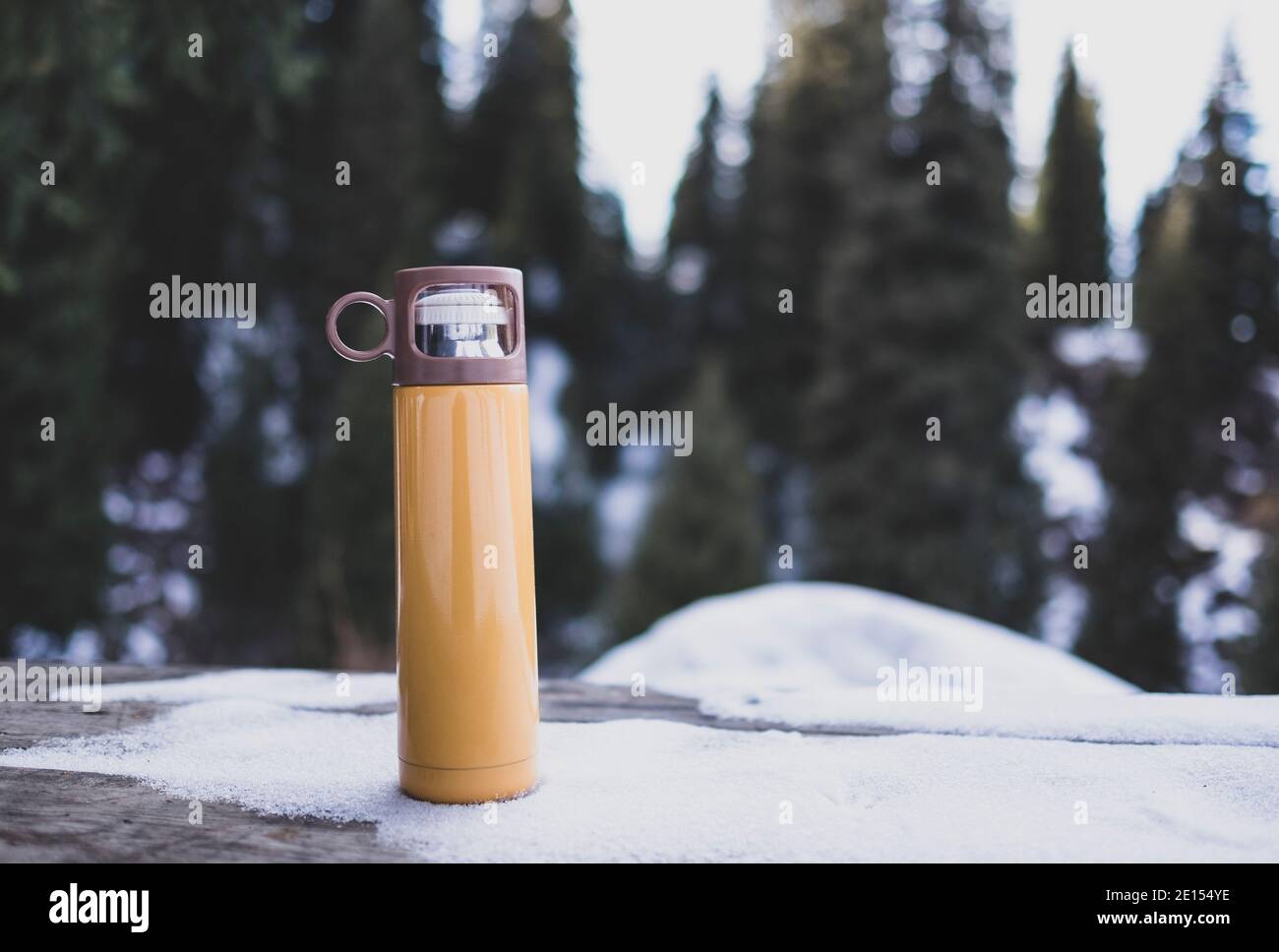 https://c8.alamy.com/comp/2E154YE/yellow-thermos-on-wooden-table-in-winter-outdoor-2E154YE.jpg