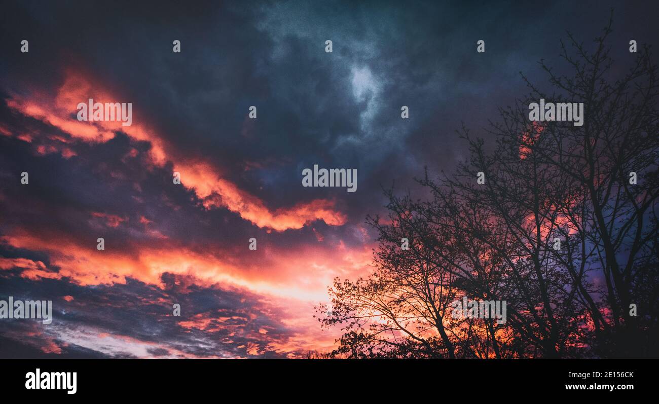 Dramatischer Panorama Wolkenhimmel mit schrillen Farben in hoffnungsvolle Jenseits Stimmung. Morgenröte im Frühling mit spektakulären Wolken. Stock Photo