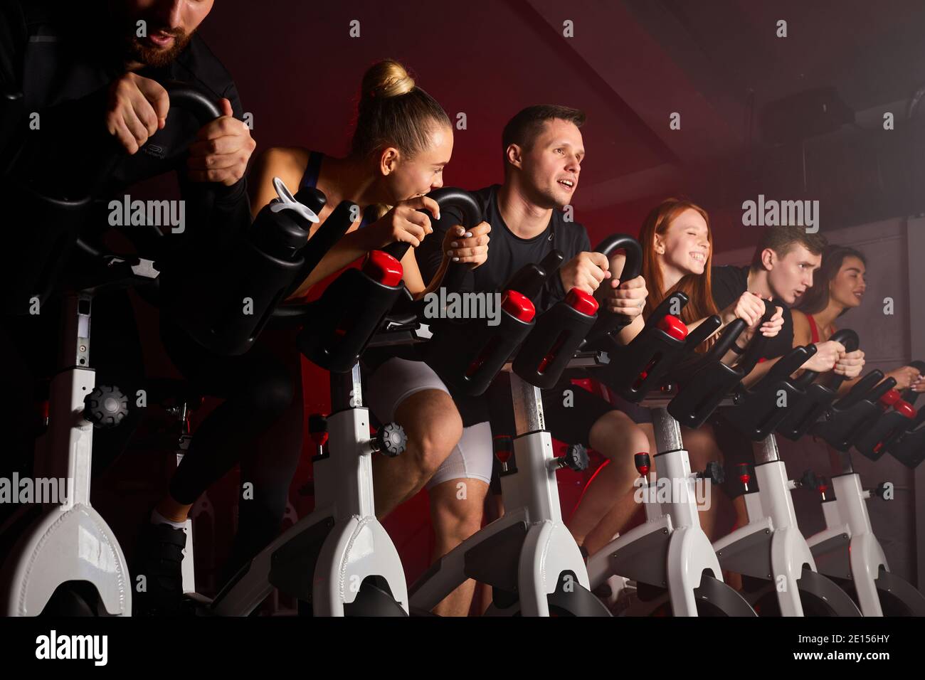 Pindiling Exercise group in a row exercise in the gym, sports friends pedaling, sitting on ...