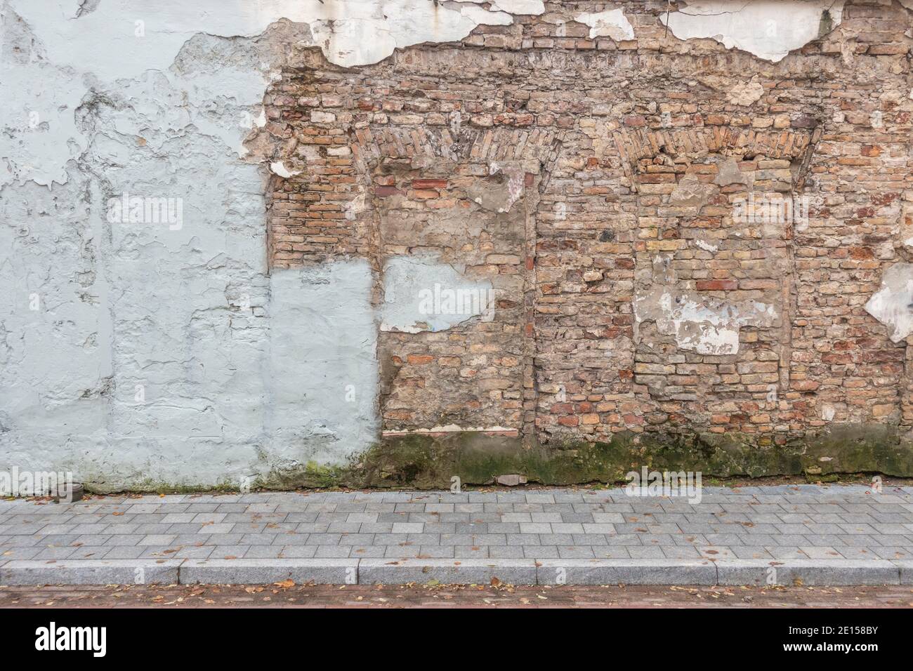 Urban street background. Old grunge obsolete brick wall and pavement Stock Photo