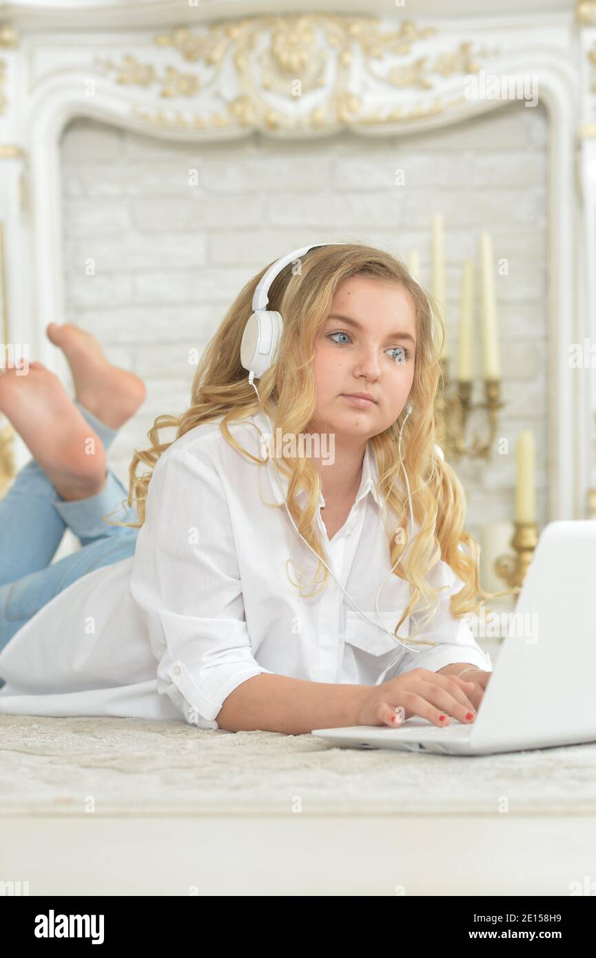 Teenage girl in headphones lying on floor Stock Photo - Alamy