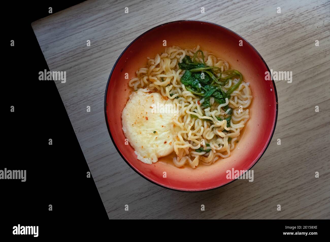 a bowl of instant noodles with eggs and vegetables by the window Stock Photo