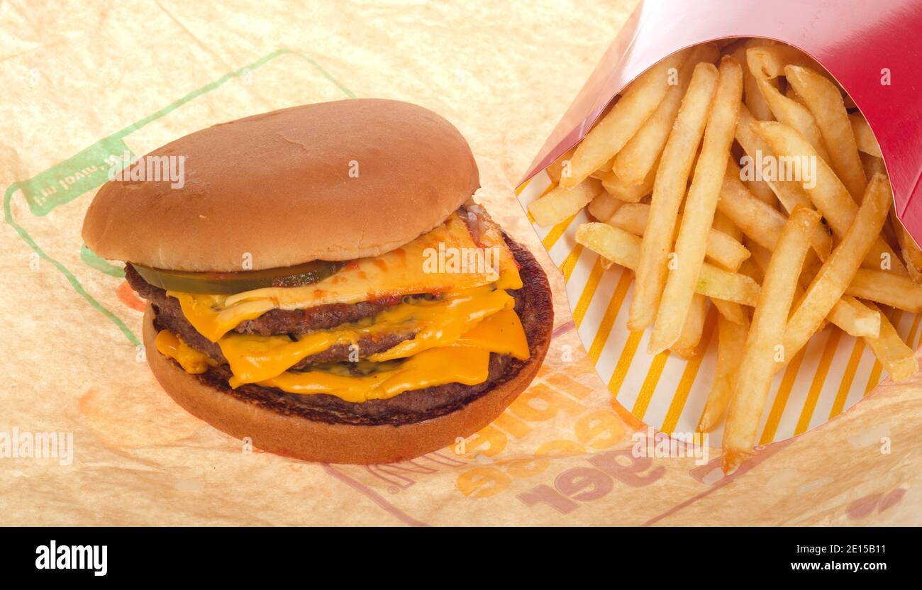 McDonald’s triple cheeseburger with french fries or chips on wrapper Stock Photo