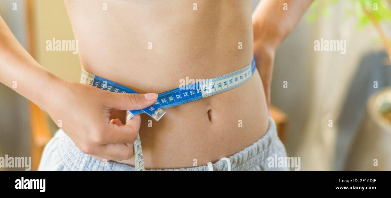 Young Slim Woman Measuring Her Waist by Measure Tape Free Stock Photo