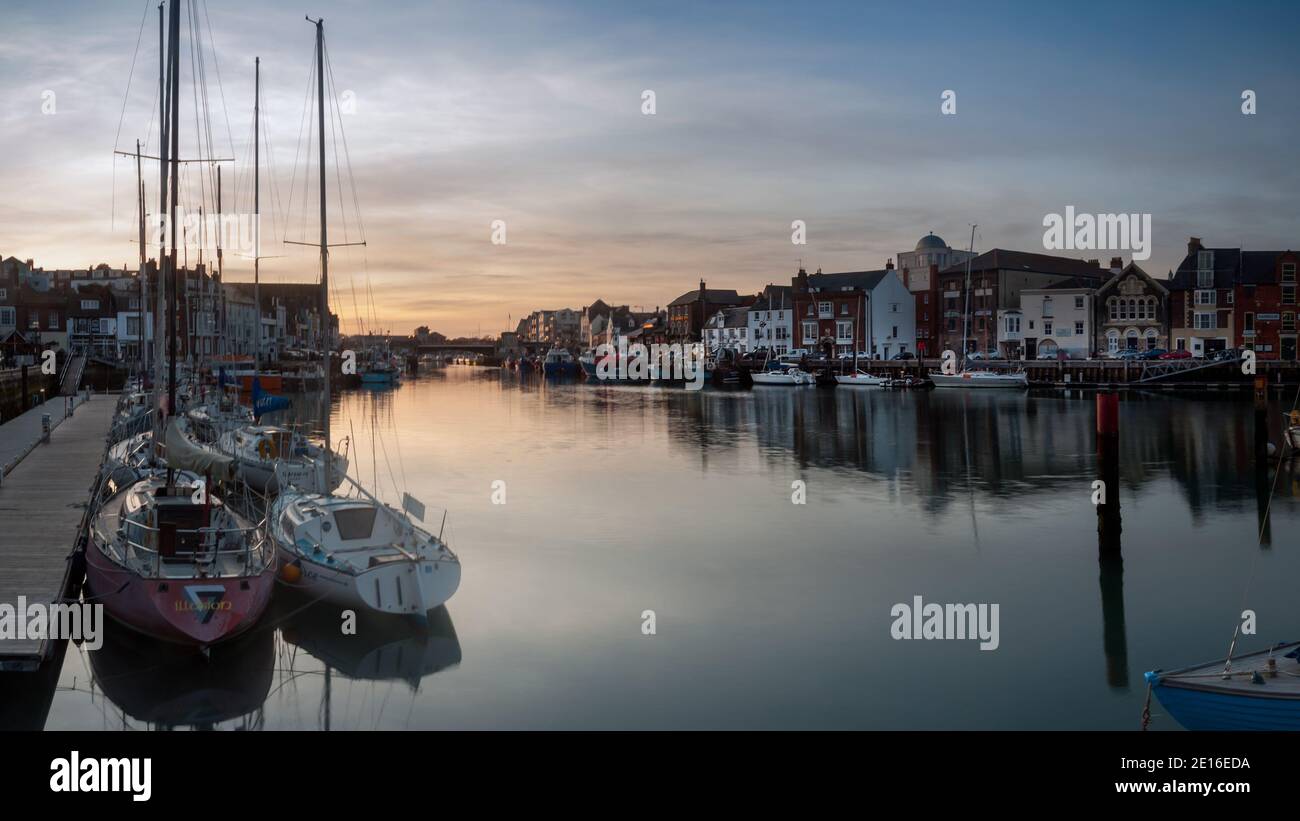 WEYMOUTH, DORSET, UK - MARCH 15, 2009:  View of the Old Harbour at night with boats moored along the quay Stock Photo