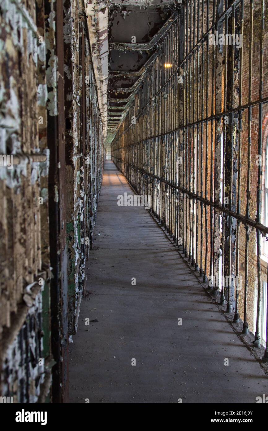 Abandoned Prison Interior. Row of empty cells on cell block of abandoned prison in vertical orientation. Stock Photo