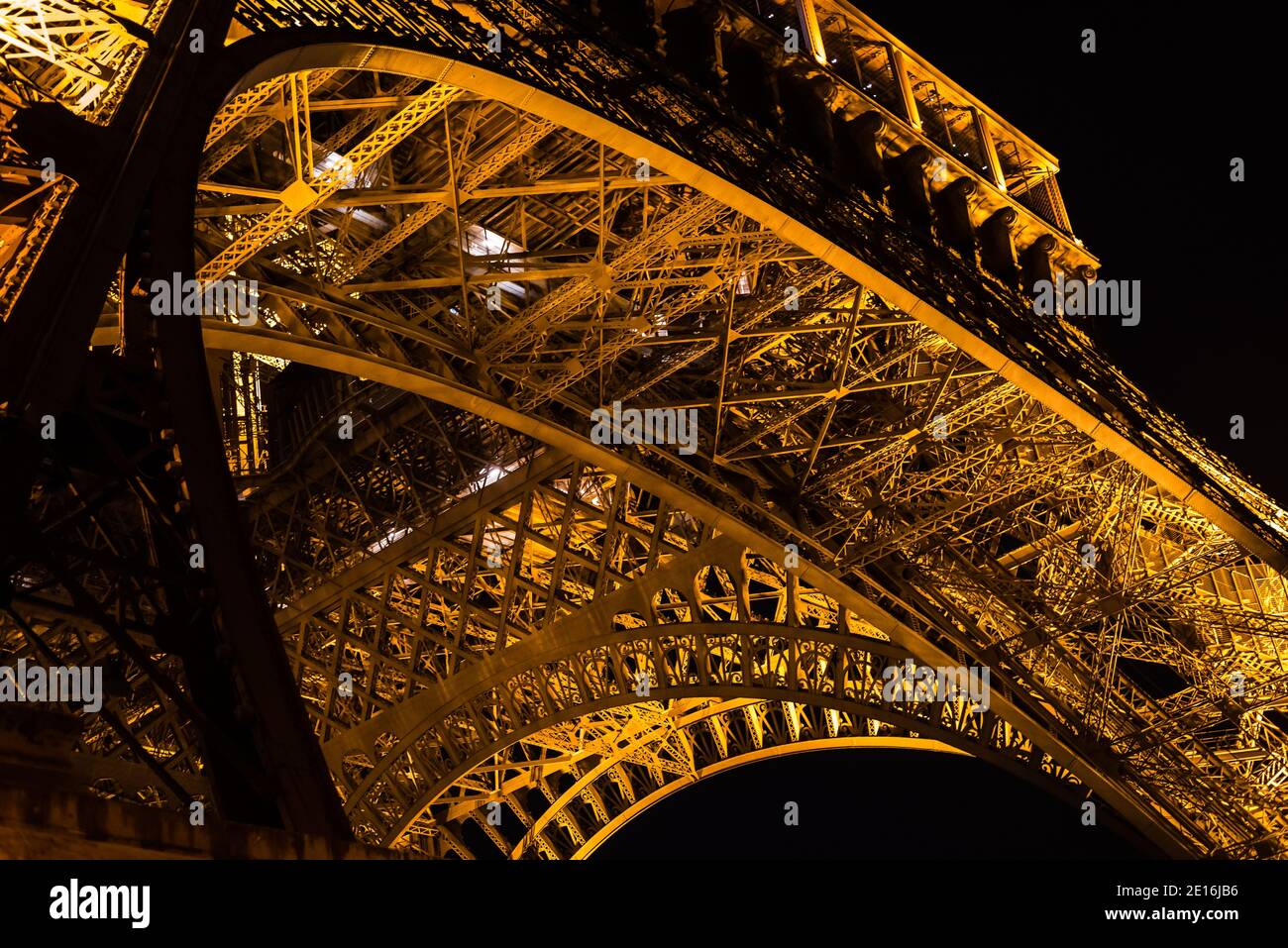 Iron web under the Eiffel Tower at night in Paris, France Stock Photo