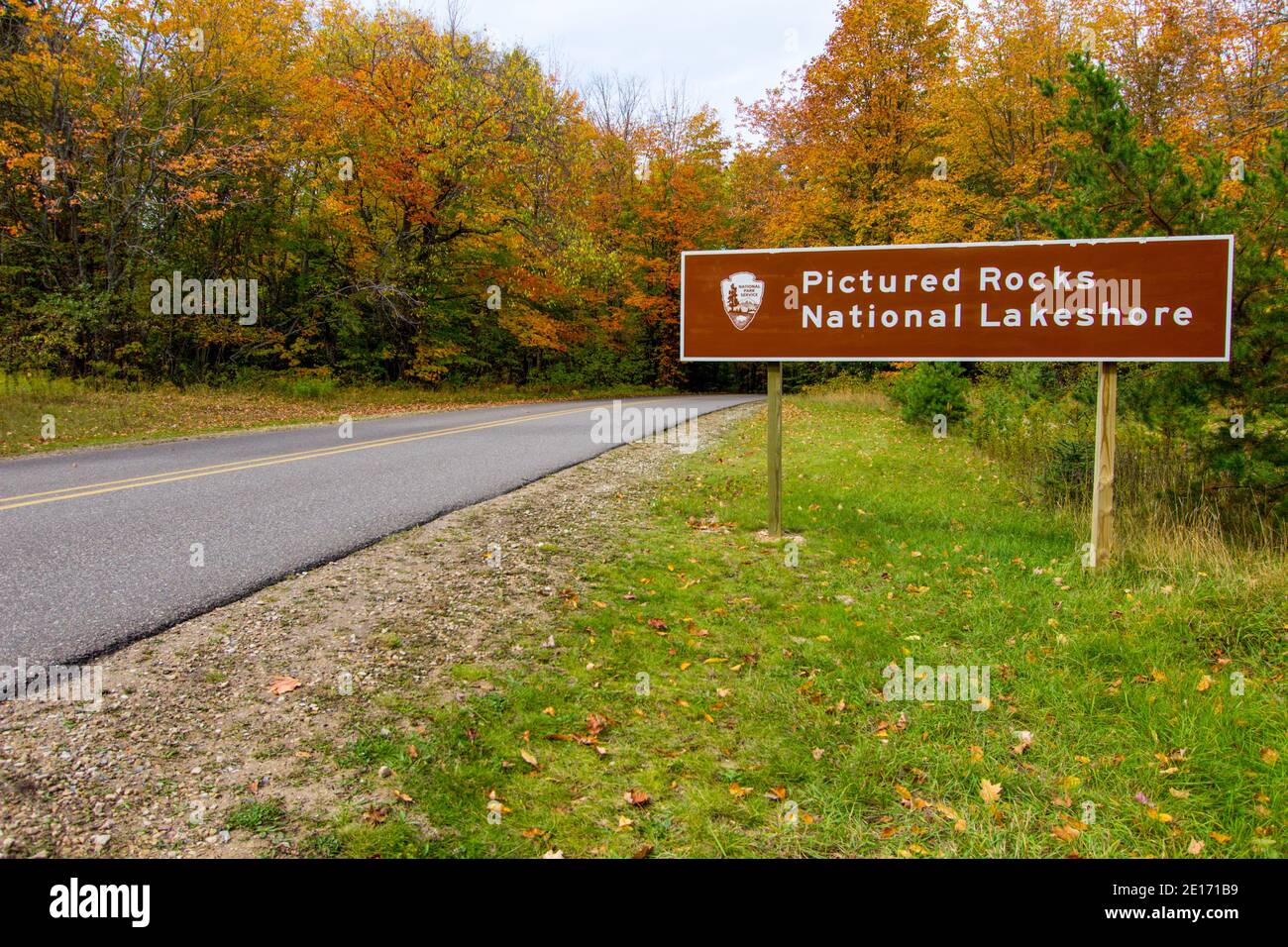 Munising, USA -Beautiful vibrant lush fall foliage surround the entrance sign to Pictured Rocks National Lakeshore in the Upper Peninsula of Michigan. Stock Photo