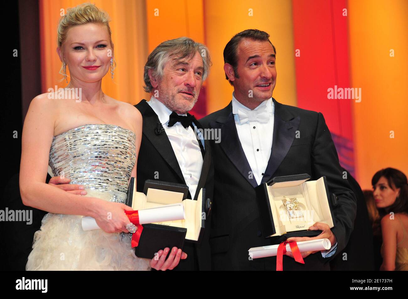 L-R) Kirsten Dunst (Best Performance by an Actress), Jury President Robert  De Niro and Jean Dujardin (Best Performance by an Actor) during the Awards  ceremony of the 64th Cannes International Film Festival,