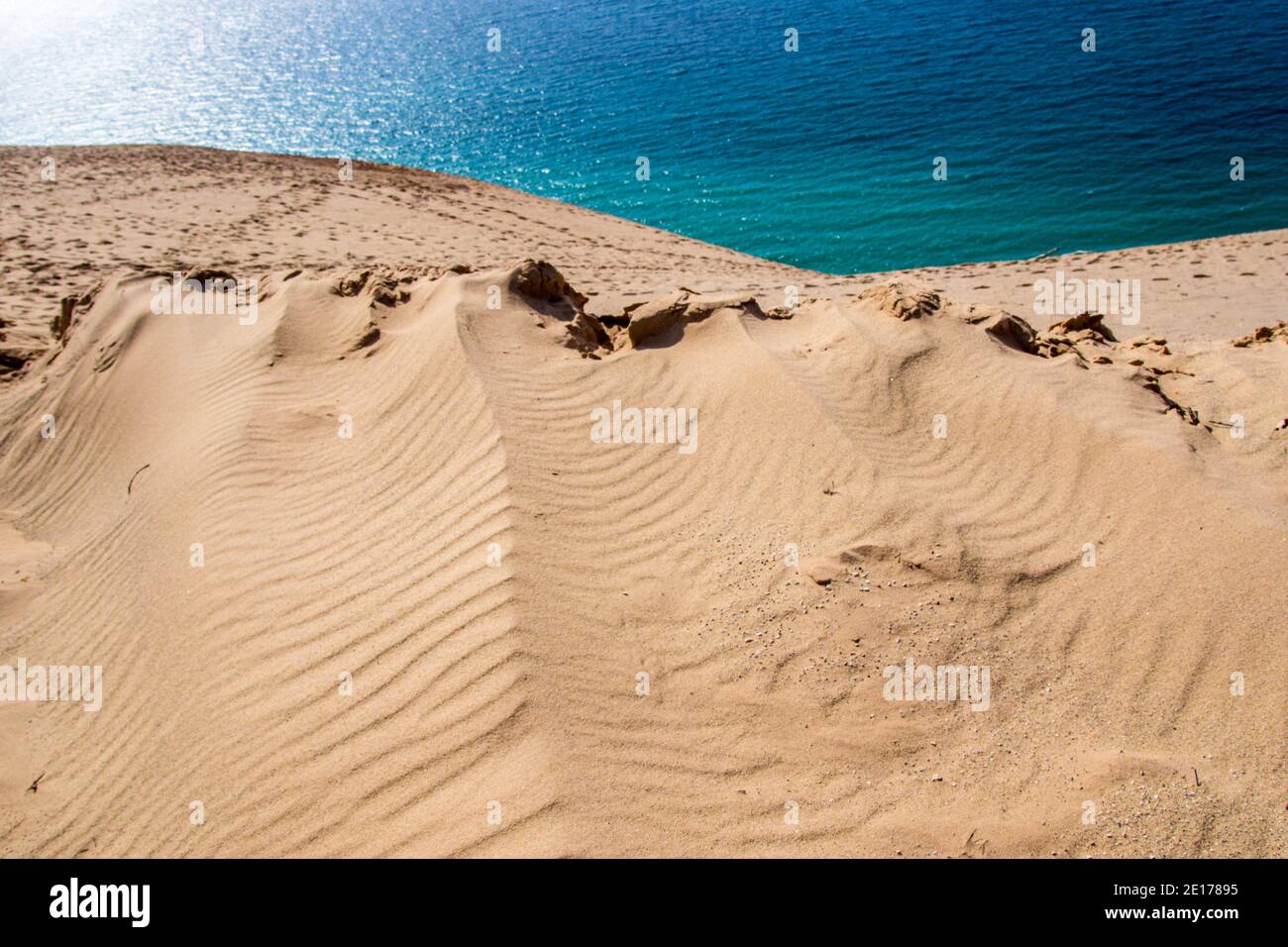 Massive sand dune overlook and the clear blue water of Lake Michigan at the Sleeping Bear Dunes National Lakeshore in Michigan. Stock Photo