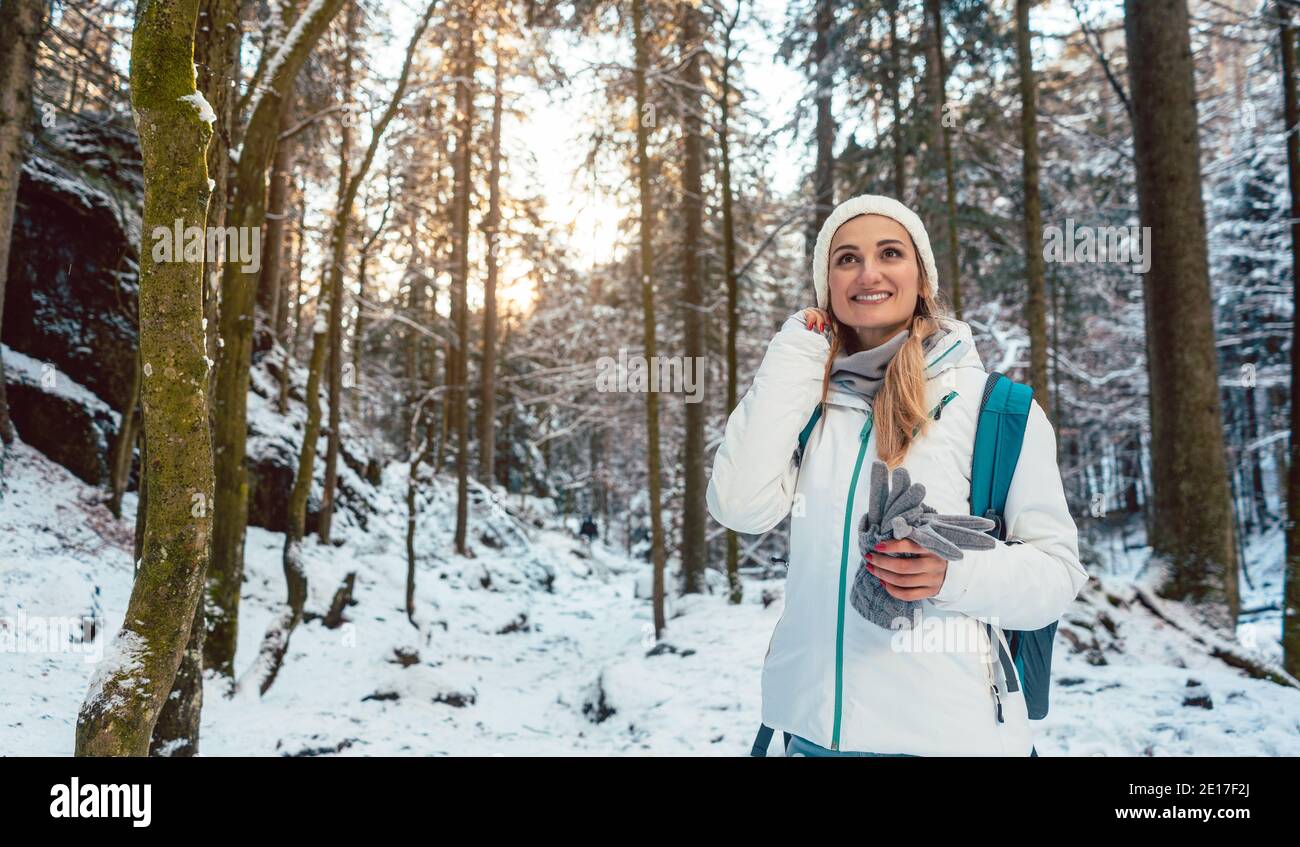 Woman on winter hike enjoying the sunset in the forest Stock Photo