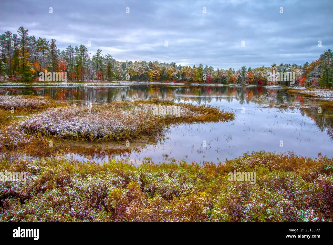 Michigan Autumn Landscape. First snow and vibrant fall colors at a small wilderness lake in Tahquamenon Falls State Park in the Upper Peninsula. Stock Photo