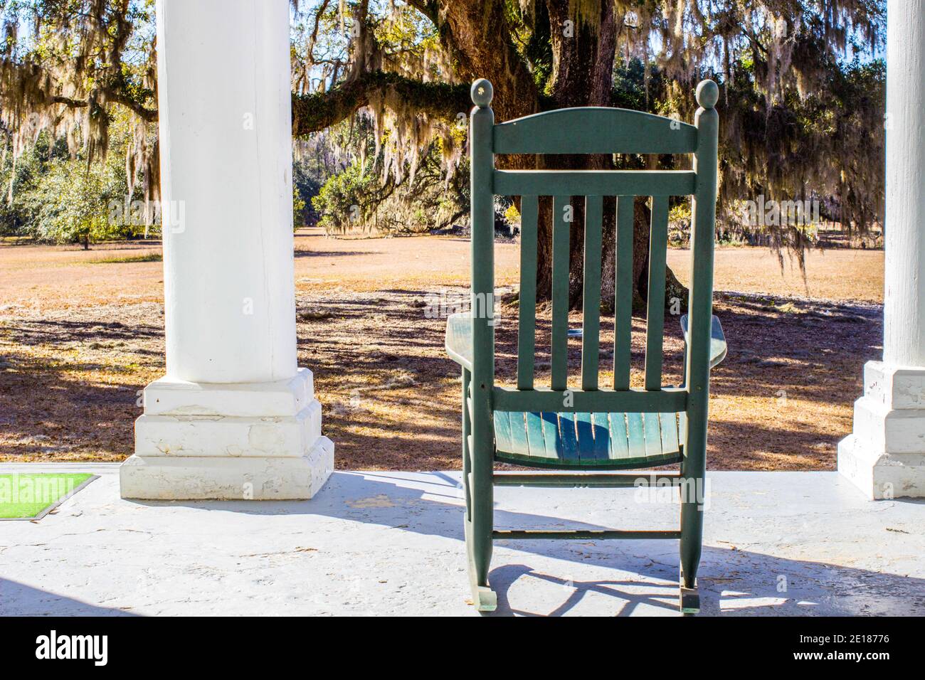 Single empty rocking chair on the front porch of an antebellum style house in the southern United States. Stock Photo
