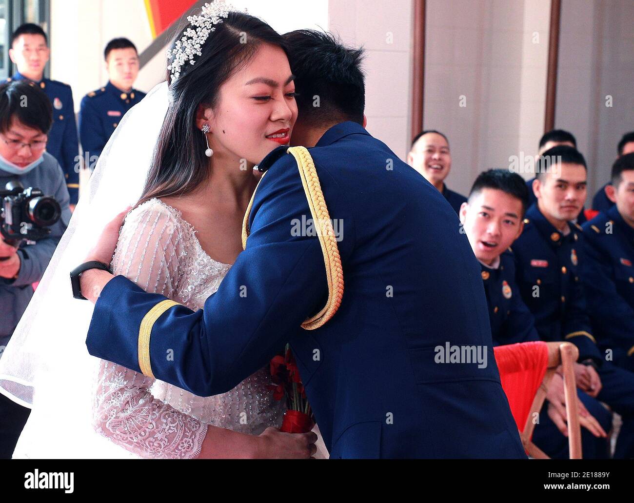 Shanghai. 4th Jan, 2021. Firefighter Yuan Yang hugs his bride Xu Lu during a group wedding ceremony in east China's Shanghai, Jan. 4, 2021. A fire brigade in Shanghai's Changning District on Monday held a group wedding for four firefighter couples, whose weddings were postponed as a result of their service in the fight against COVID-19. Credit: Chen Fei/Xinhua/Alamy Live News Stock Photo