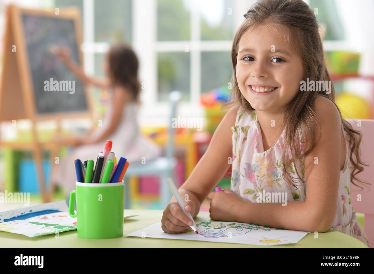 Portrait of cute smiling girl drawing at home Stock Photo - Alamy