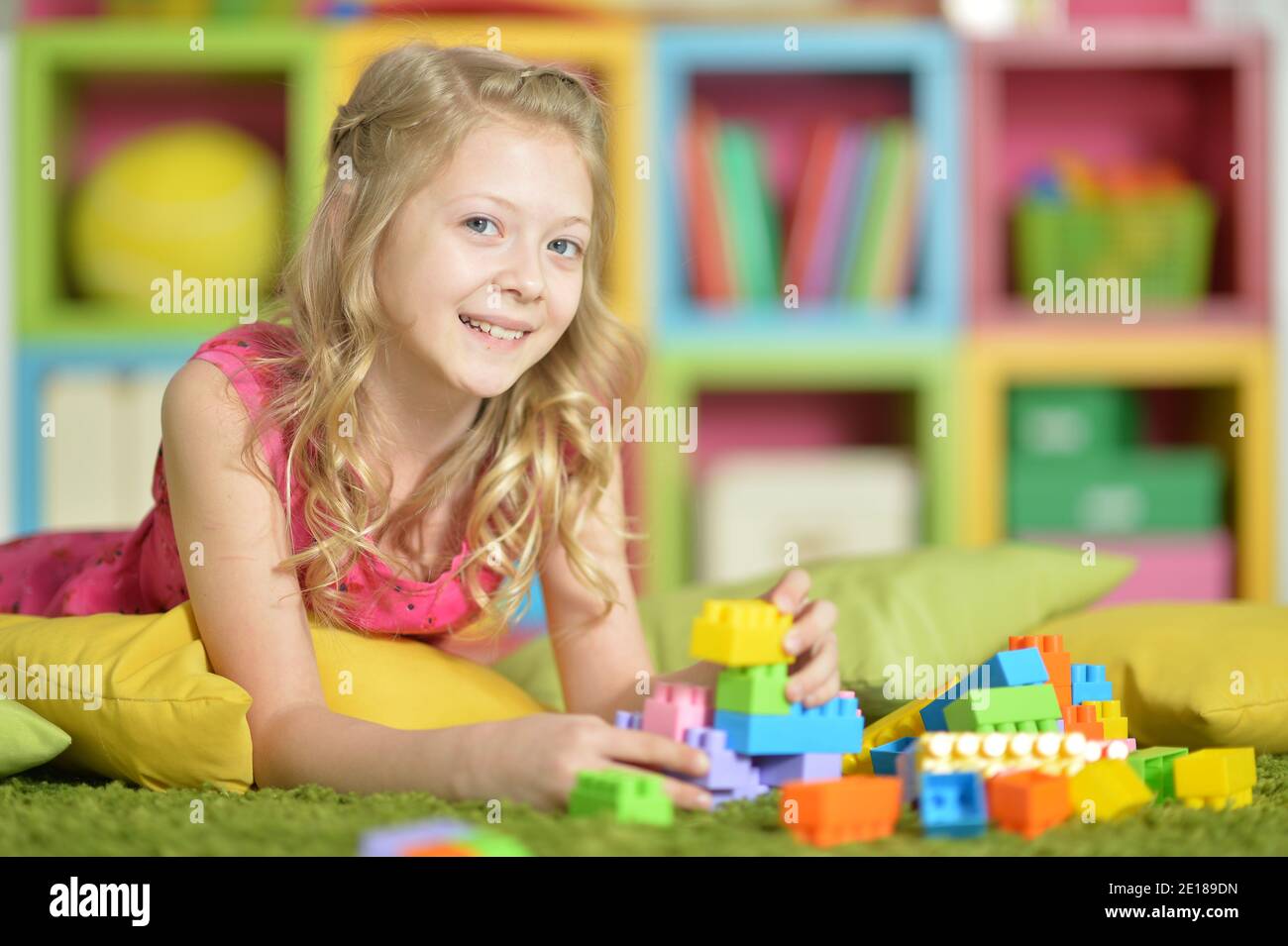 Little girl playing with colorful plastic blocks Stock Photo - Alamy