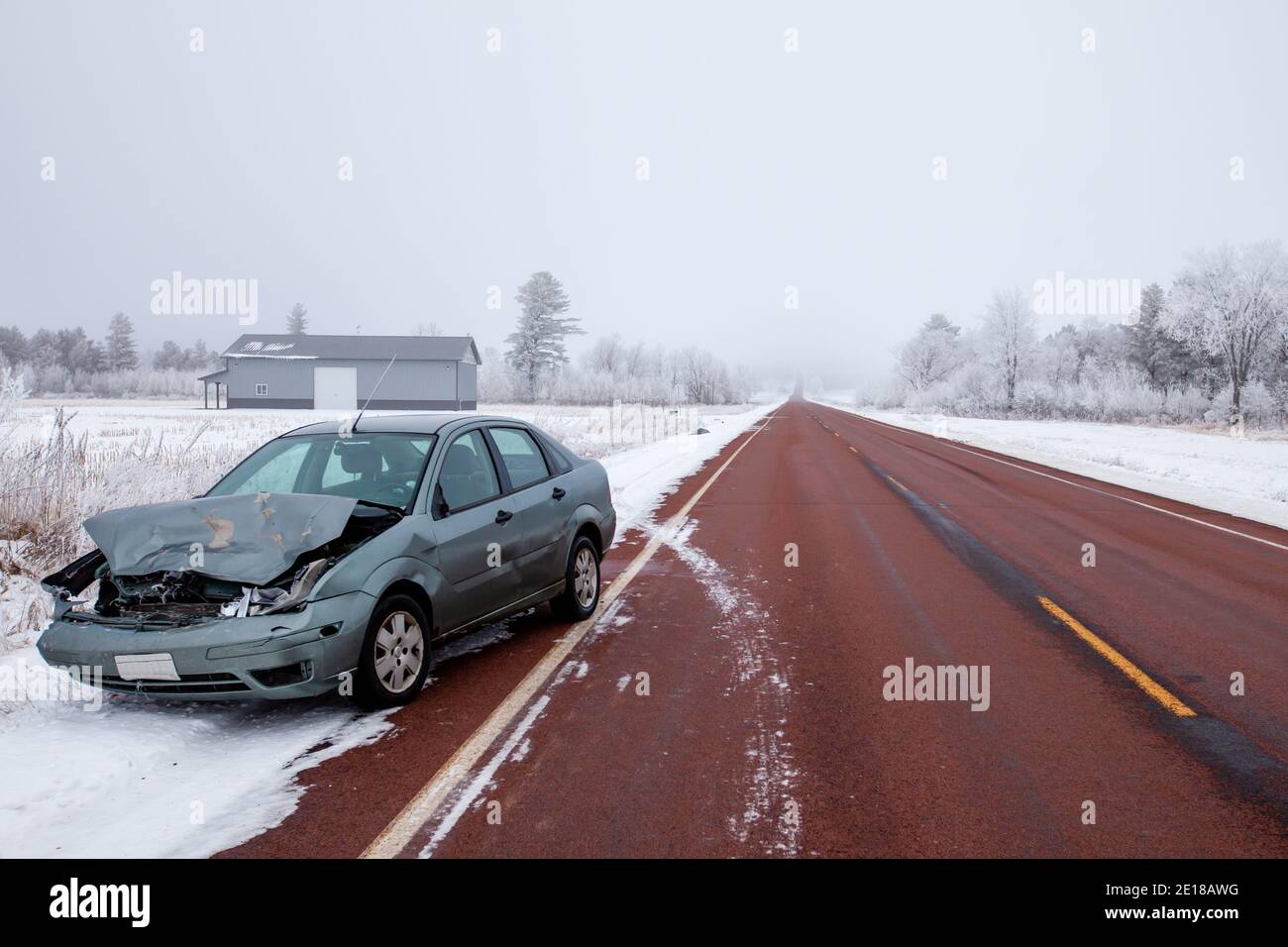 Smashed car and dead deer on the side of a Wisconsin highway in winter, horizontal Stock Photo