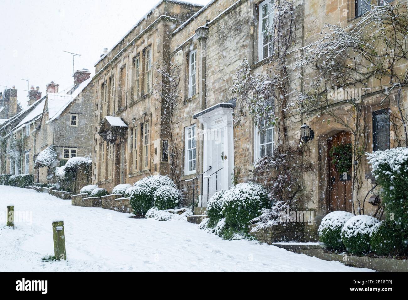 Town houses on Burford Hill in the December Snow. Burford, Cotswolds, Oxfordshire, England Stock Photo