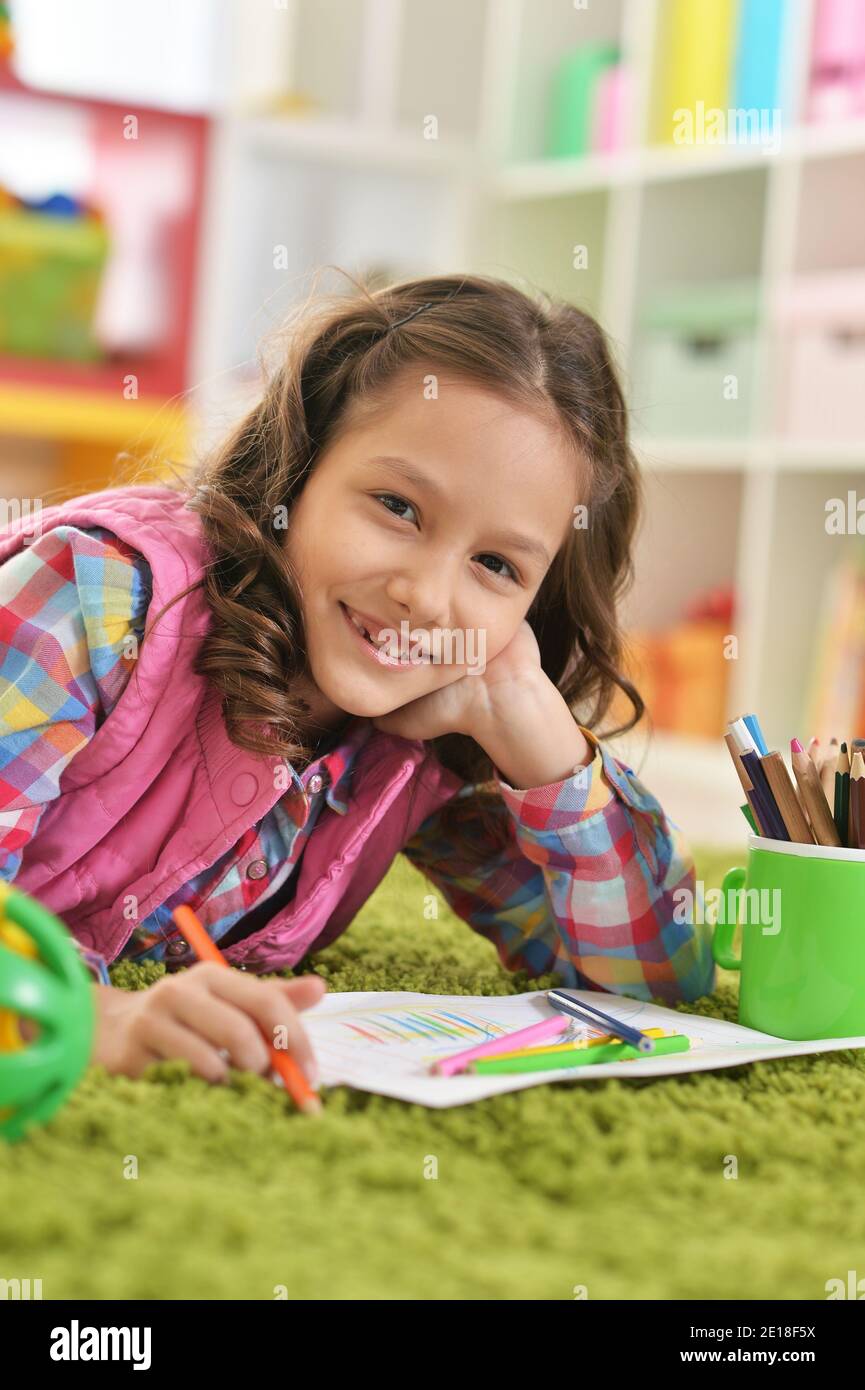 Cute girl lying on floor and drawing Stock Photo - Alamy