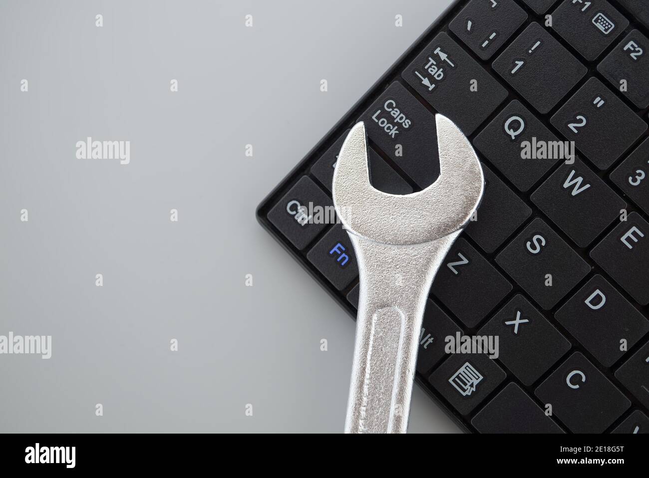 Electronic technical support concept - spanner on computer keyboard Stock Photo