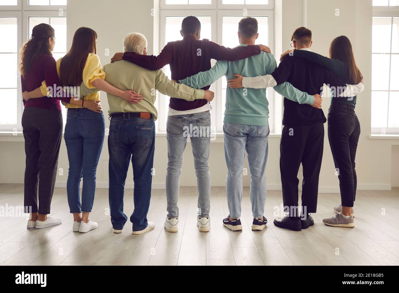 Team of confident people standing together and hugging ready to support