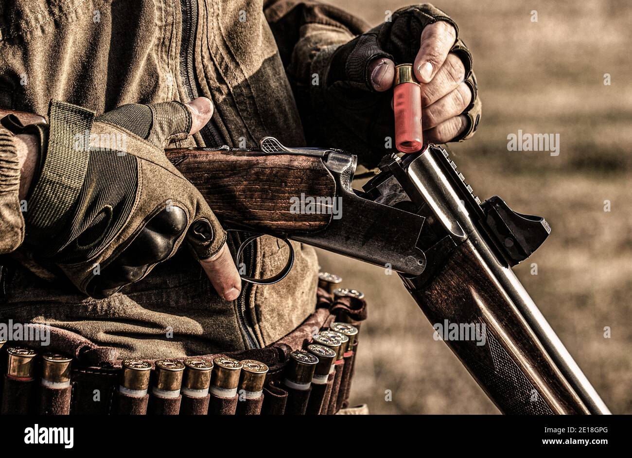 Male hunter in ready to hunt. Closeup. Hunter man. Hunting period. Male with a gun, rifle. Man is charging a hunting rifle. Process of hunting during Stock Photo