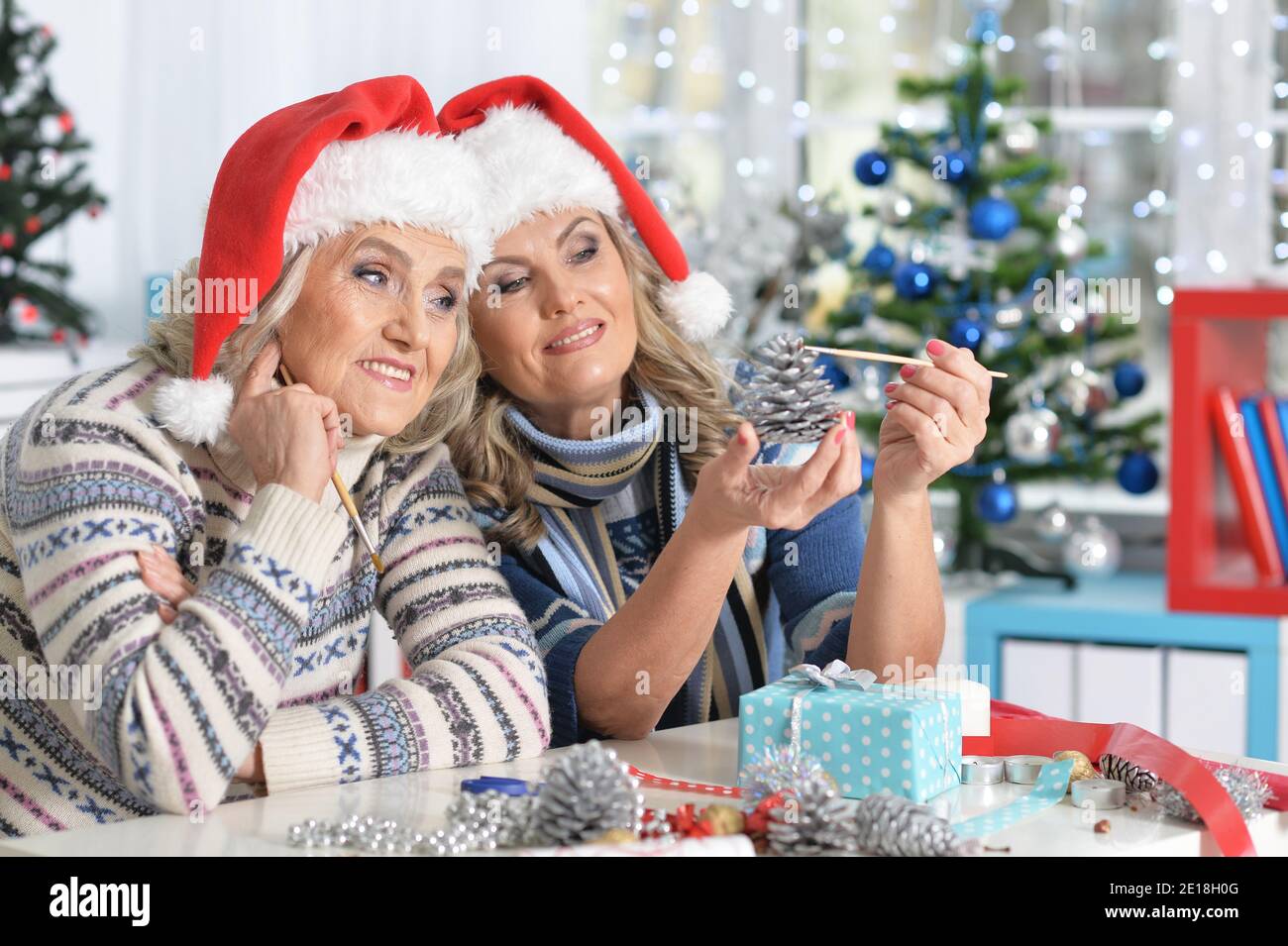 Two mature women in Santa hats celebrating Christmas Stock Photo - Alamy