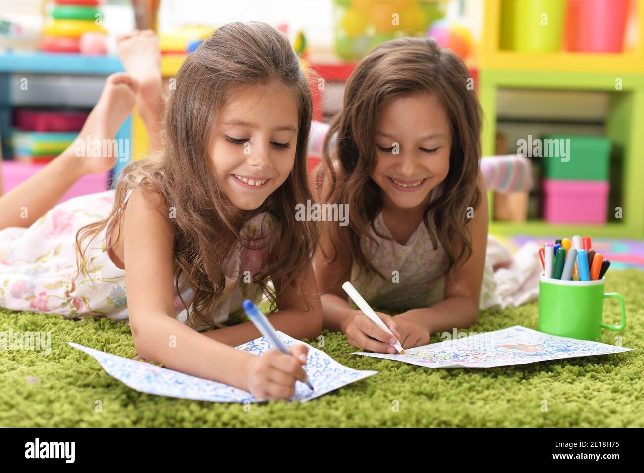 Two cute little girls drawing with pencils Stock Photo - Alamy