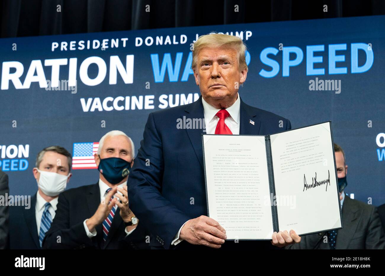 President Donald Trump, joined by Vice President Mike Pence and senior White House staff, displays his signature after signing an Executive Order ensuring that the American people have priority access to COVID-19 vaccines developed in the U.S. or procured by the U.S. Government, at the Operation Warp Speed Vaccine Summit Tuesday, December 8, 2020, in the South Court Auditorium of the Eisenhower Executive Office Building at the White House. Stock Photo