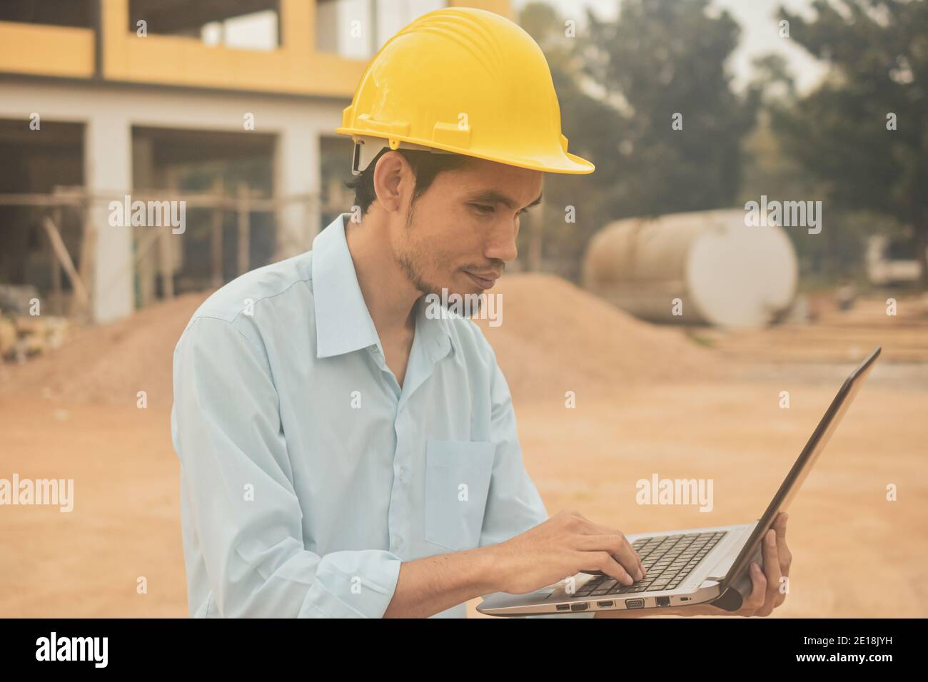 Engineering construction holding computer notebook inspection work at estate building project Stock Photo