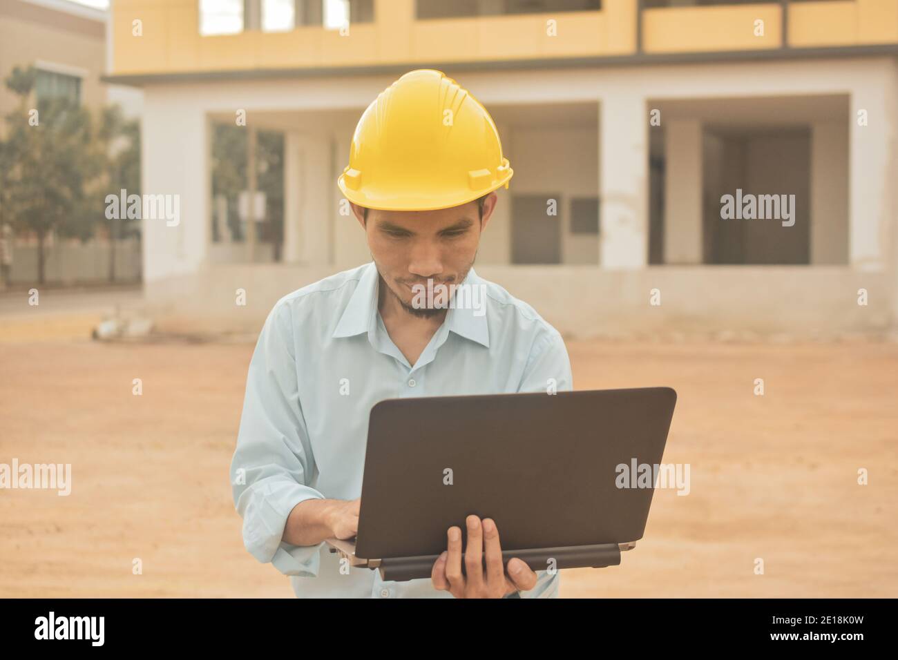 Engineering construction holding computer notebook inspection work at estate building project Stock Photo