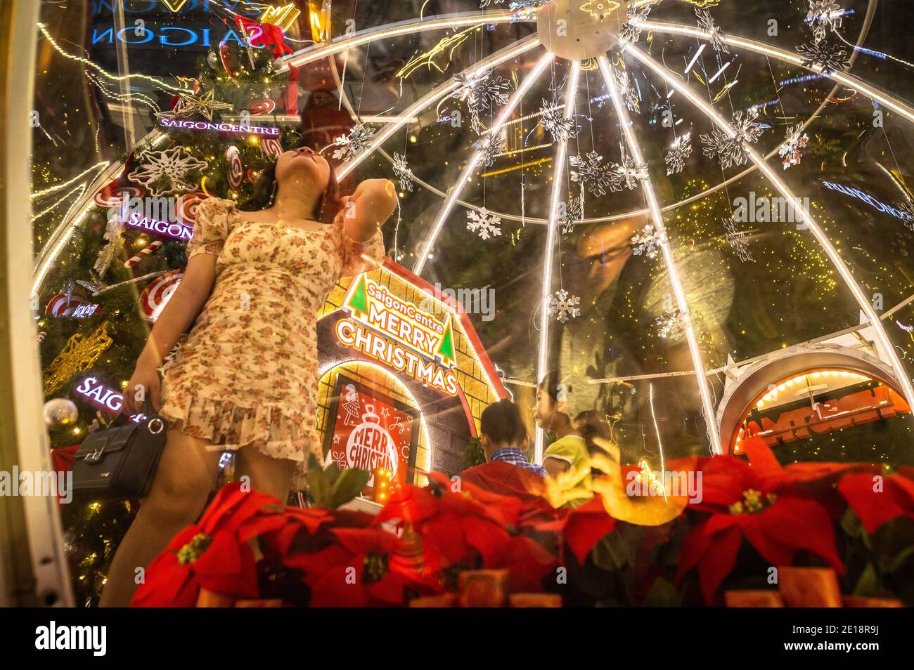 People posing among the Christmas decorations outside of Saigon Center, Ho Chi Minh City, Vietnam Stock Photo