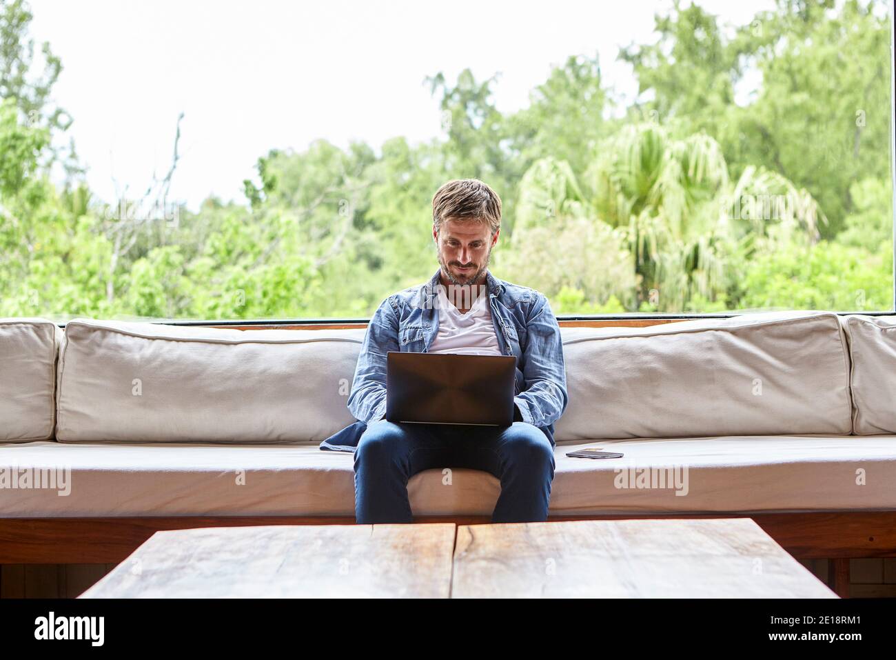 Mid adult man using laptop Stock Photo
