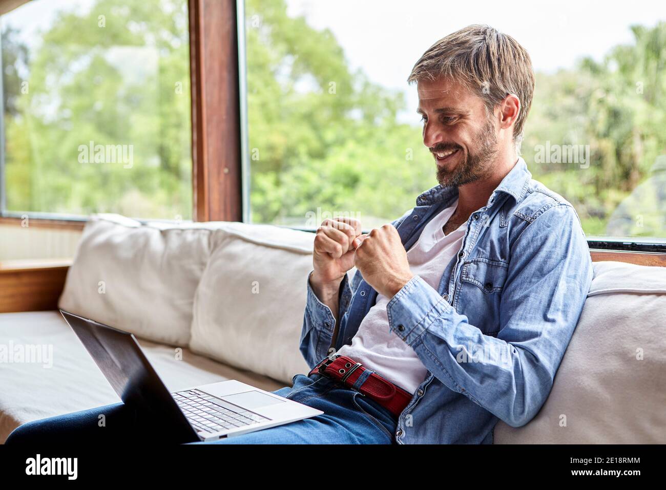 Cheerful mid adult man using laptop Stock Photo