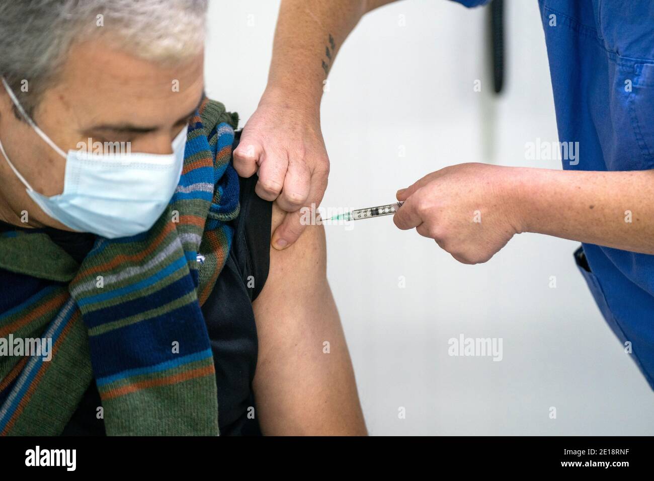 Nurse vaccinating a man with the Pfizer-BioNTech Covid 19 vaccine Stock Photo
