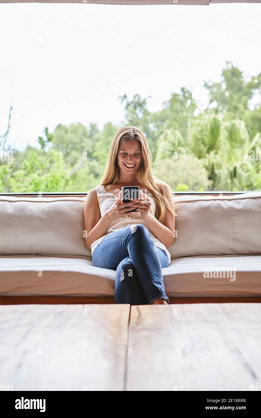 Smiling mid adult woman using smartphone Stock Photo
