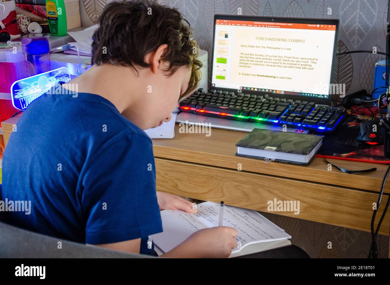 Reading, UK - 5th January 2021: Following the announcement by British Prime Minister Boris Johnson that England is to enter a new lockdown due to coronavirus, a secondary school child sits at home in front of the family laptop computer to do online learning. His school has sent lessons in the form of Microsoft PowerPoint presentations and communicates with children via tools such as Microsoft Teams. Stock Photo