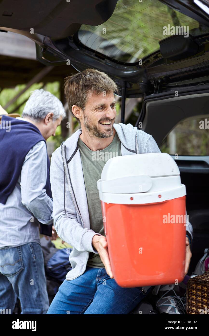 Mid adult man holding cool box Stock Photo